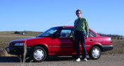 A red car, with countryside